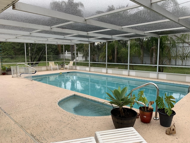 view of swimming pool featuring a lanai and a patio