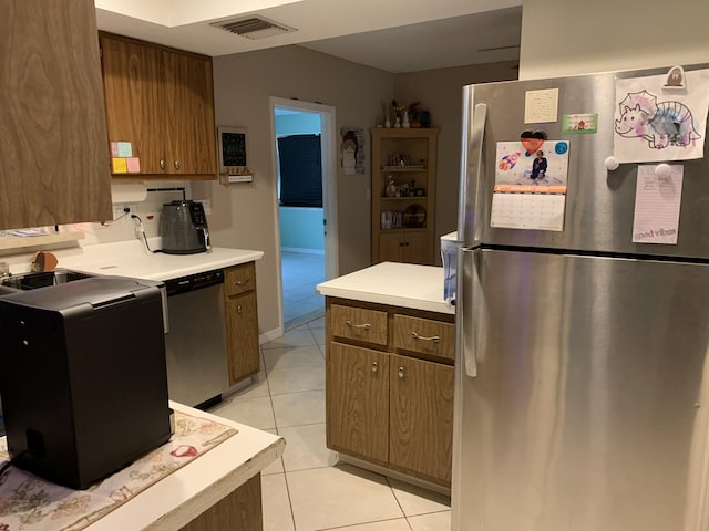 kitchen featuring stainless steel appliances and light tile patterned flooring