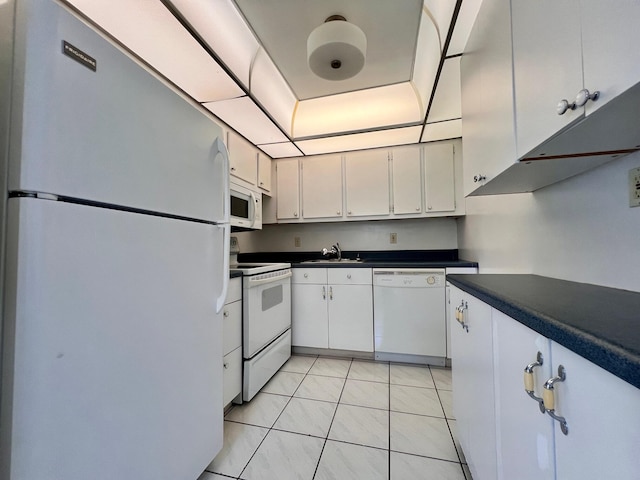 kitchen featuring white cabinetry, sink, light tile patterned floors, and white appliances