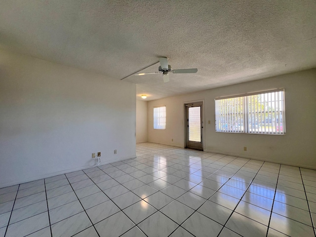 tiled empty room with a textured ceiling and ceiling fan