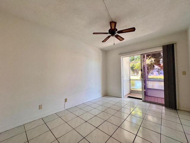 tiled spare room featuring a textured ceiling and ceiling fan