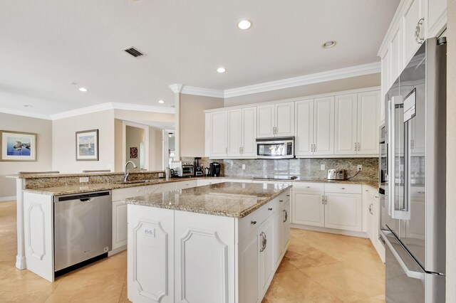 kitchen featuring kitchen peninsula, appliances with stainless steel finishes, backsplash, sink, and white cabinetry