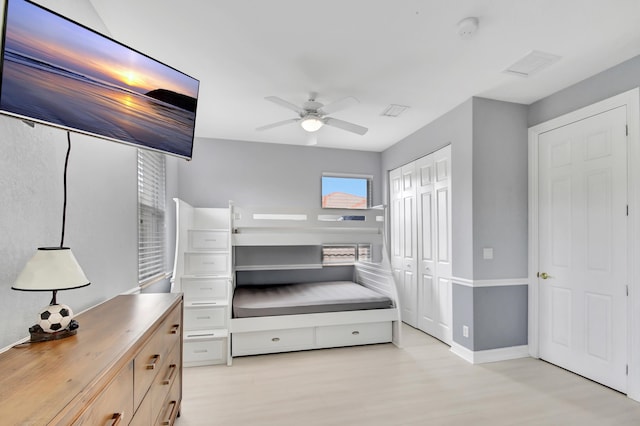 bedroom with ceiling fan, a closet, and light hardwood / wood-style floors