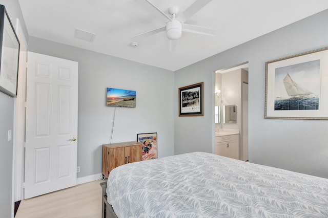 bedroom with light wood-type flooring, ensuite bath, and ceiling fan