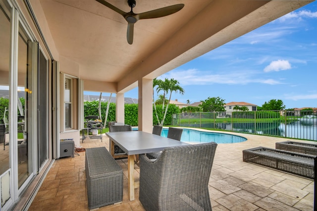 exterior space with ceiling fan, a water view, and a patio