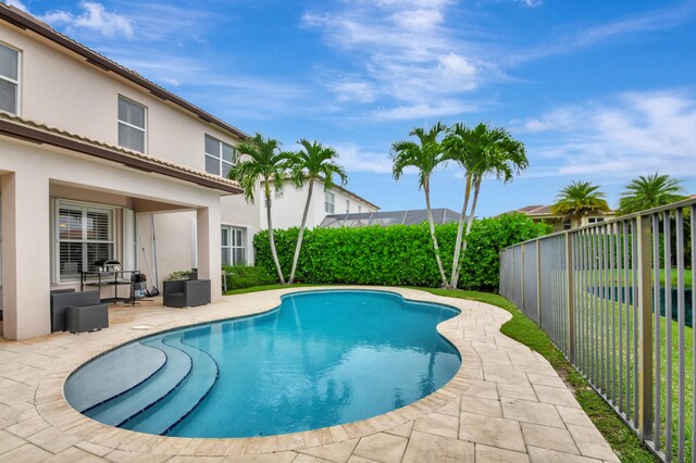 view of pool with an outdoor living space and a patio