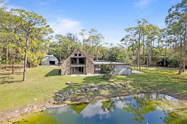 back of house featuring a yard and a water view