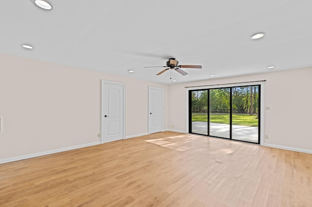 empty room with ceiling fan and light hardwood / wood-style flooring