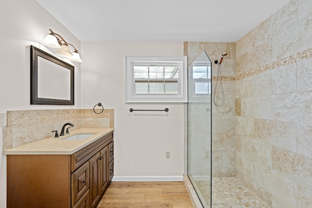 bathroom featuring tiled shower, vanity, and hardwood / wood-style flooring