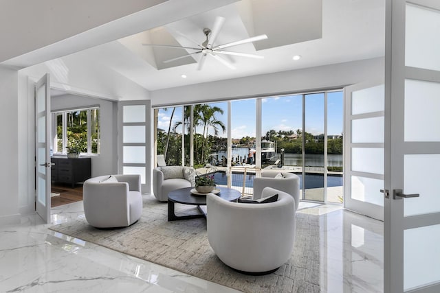 living room with ceiling fan, french doors, a water view, and a healthy amount of sunlight