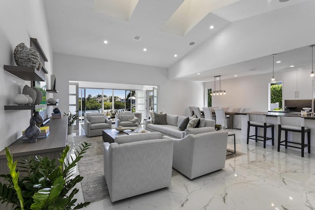 living room with a skylight and high vaulted ceiling