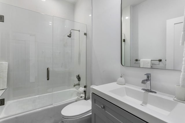 full bathroom featuring vanity, enclosed tub / shower combo, and toilet