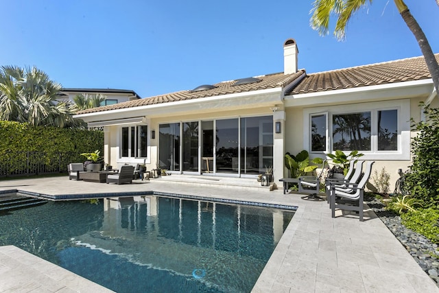 rear view of house featuring a fenced in pool, outdoor lounge area, and a patio