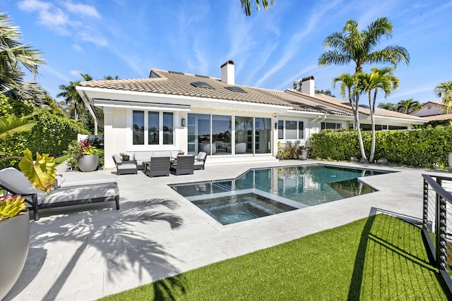 rear view of property featuring an outdoor living space, a patio, and a swimming pool with hot tub