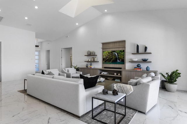 living room with high vaulted ceiling and a skylight