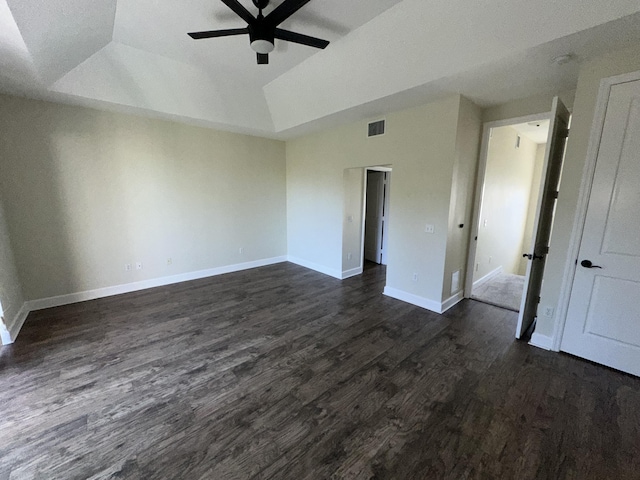 spare room with dark hardwood / wood-style flooring, a tray ceiling, and ceiling fan