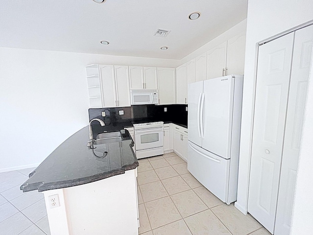 kitchen featuring white appliances, sink, light tile patterned floors, white cabinetry, and kitchen peninsula