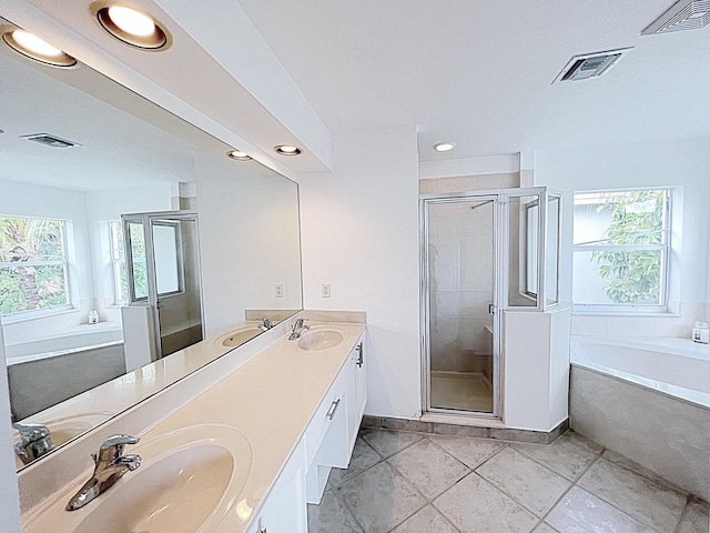 bathroom featuring tile patterned flooring, plenty of natural light, vanity, and independent shower and bath