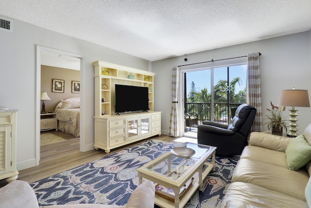 living room featuring a textured ceiling and light hardwood / wood-style flooring