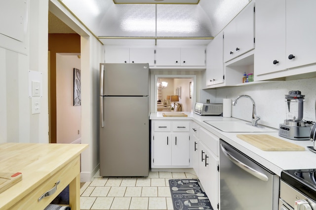 kitchen featuring white cabinets, light tile patterned floors, stainless steel appliances, and sink