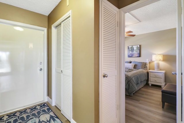 interior space featuring ceiling fan, wood-type flooring, and a textured ceiling