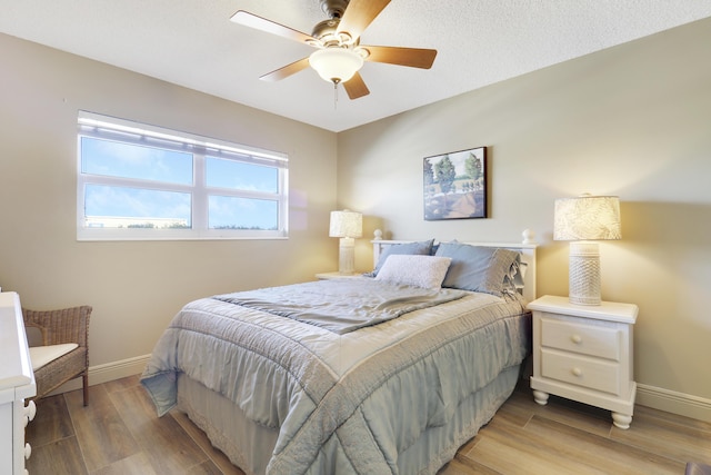 bedroom with ceiling fan and light hardwood / wood-style flooring