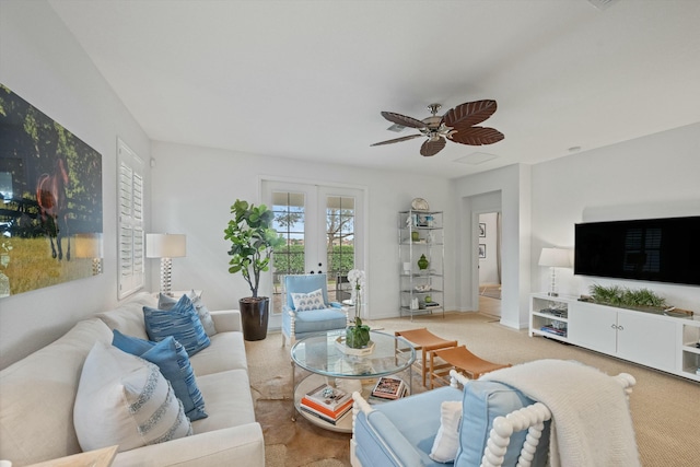 carpeted living room with ceiling fan and french doors