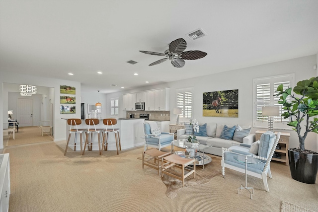 living room with ceiling fan and light colored carpet