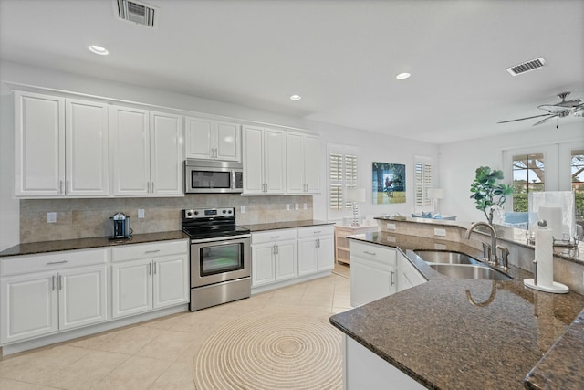 kitchen with ceiling fan, sink, stainless steel appliances, and white cabinetry