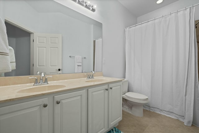 bathroom with toilet, vanity, and tile patterned flooring