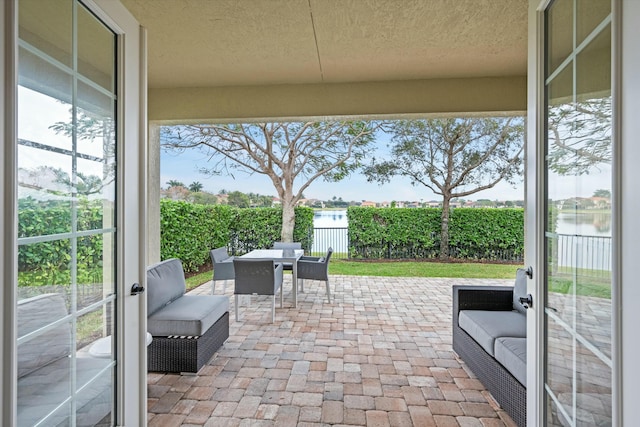 view of patio featuring a water view and french doors