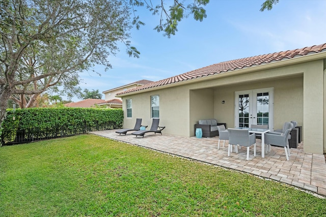 rear view of house featuring french doors, a yard, and a patio