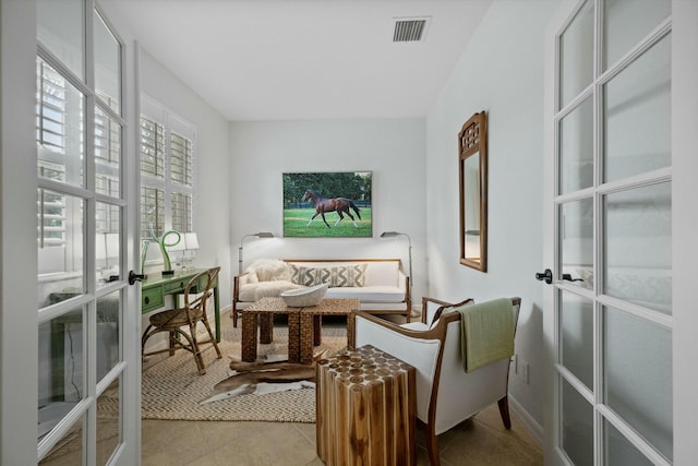 living area featuring light tile patterned floors and french doors