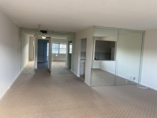 hallway featuring carpet floors and a textured ceiling