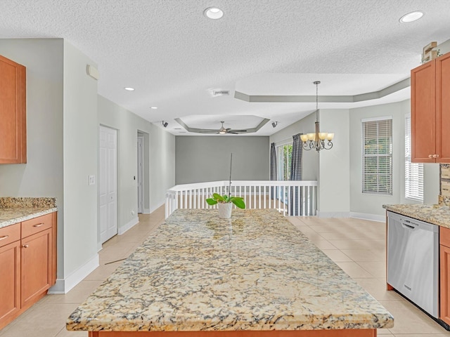 kitchen featuring stainless steel dishwasher, a center island, and a raised ceiling