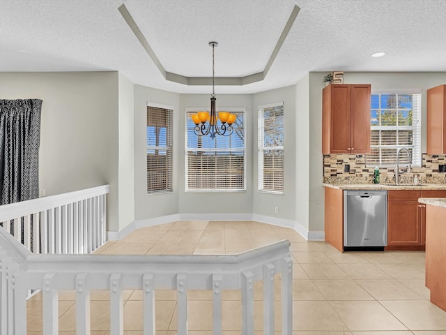 kitchen featuring decorative backsplash, sink, pendant lighting, a notable chandelier, and dishwasher