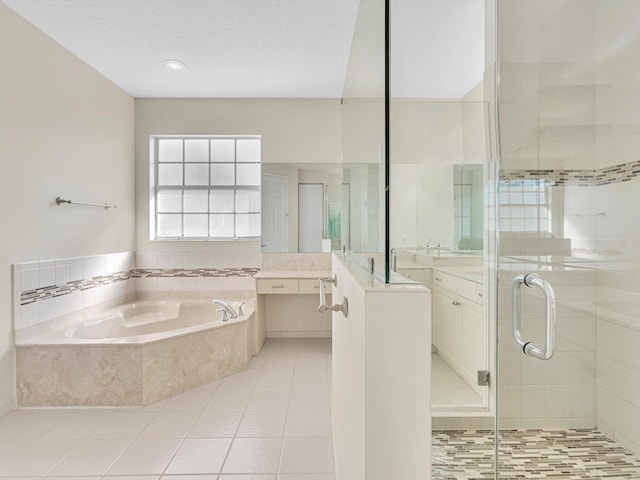 bathroom featuring tile patterned floors, separate shower and tub, vanity, and a textured ceiling