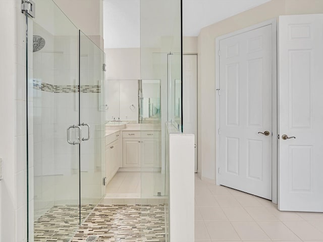 bathroom featuring a shower with door, vanity, and tile patterned flooring