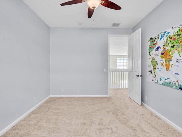 carpeted spare room with ceiling fan