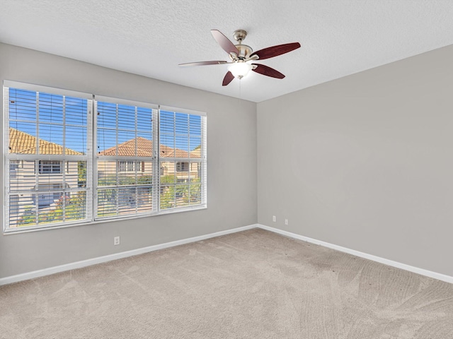 carpeted empty room featuring ceiling fan and a textured ceiling