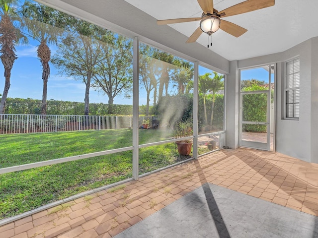 unfurnished sunroom featuring ceiling fan