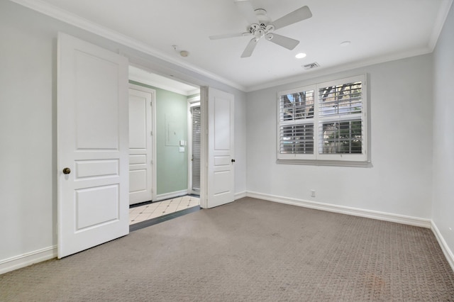 unfurnished bedroom with ceiling fan, light colored carpet, and crown molding