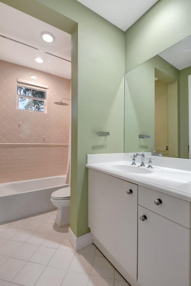 full bathroom with tiled shower / bath, tile patterned flooring, vanity, and toilet