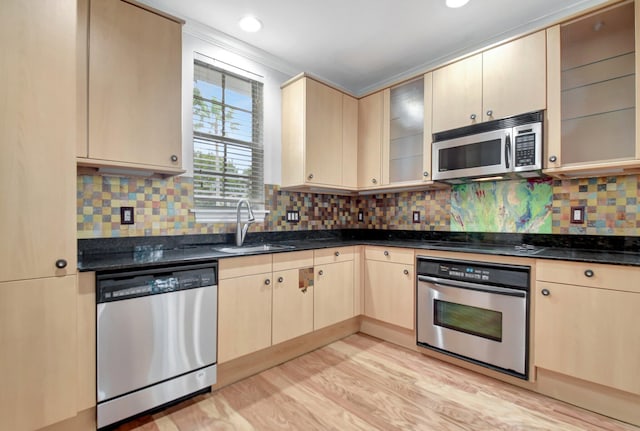 kitchen featuring sink, light brown cabinets, light wood-type flooring, and appliances with stainless steel finishes