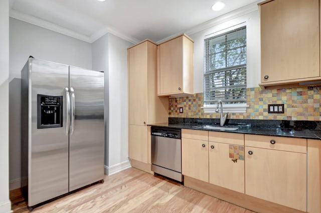 kitchen with light wood-type flooring, stainless steel appliances, sink, light brown cabinets, and dark stone countertops