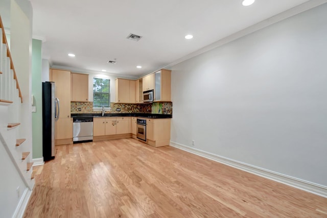 kitchen featuring appliances with stainless steel finishes, light brown cabinetry, light hardwood / wood-style flooring, and crown molding