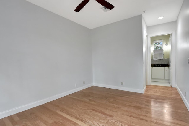 empty room featuring ceiling fan and light hardwood / wood-style flooring