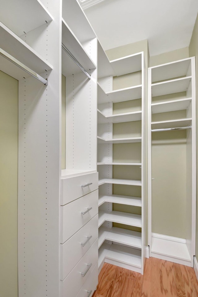 walk in closet with hardwood / wood-style floors