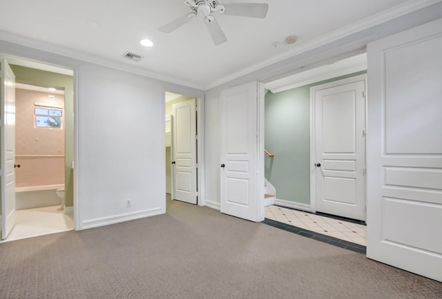 unfurnished bedroom featuring light colored carpet, ensuite bath, ceiling fan, and crown molding