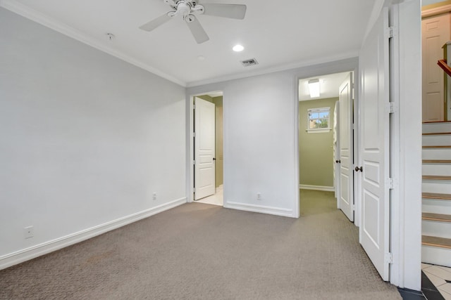 unfurnished bedroom featuring ceiling fan, crown molding, light carpet, and a closet